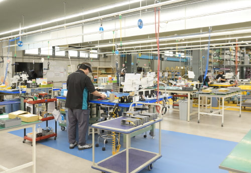 工場内の組立・検査工程。工場見学を前提に、明るく余裕のあるレイアウトで、従業員のオープンマインドも醸成される。